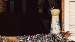 Vaso decorativo com flores em ambiente tranquilo, simbolizando homenagem e memória em espaço de despedida.